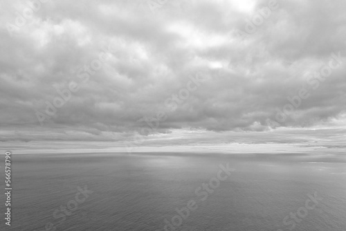 Black and white photo. View of the gray clouds and water in the ocean.