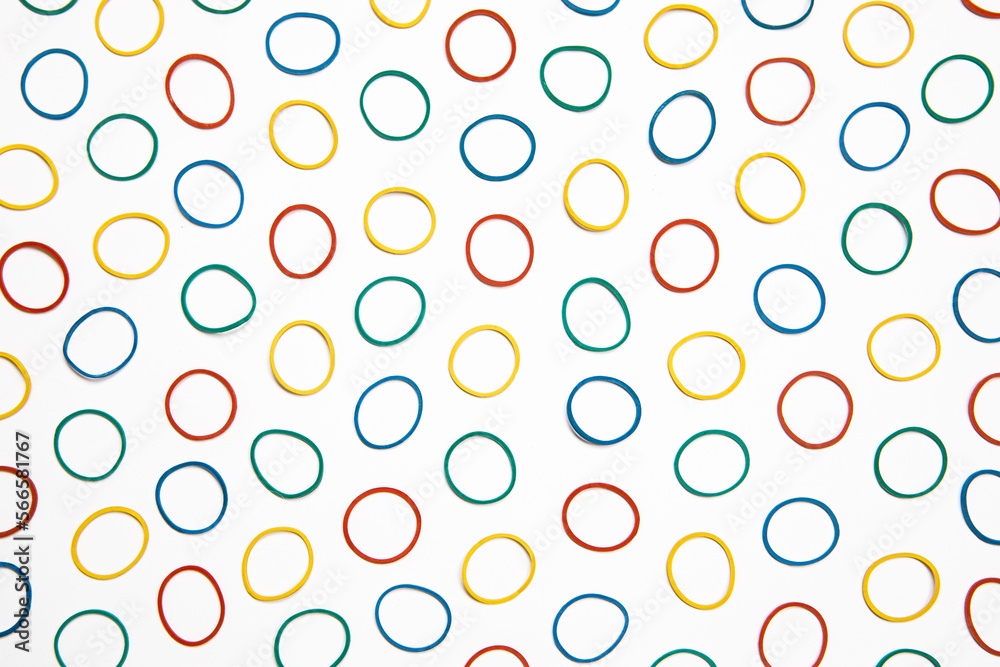 Flat lay colourful rubber band background. Office supply, elastic band. Many circles on white background, abstract pattern.