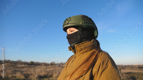 Female ukrainian army soldier walking at the field. Woman in military uniform and helmet going on meadow at sunset. Ukraine victory against Russian aggression. Invasion resistance concept. Slow motion © olehslepchenko
