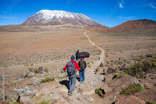 A porter carrying heavy load on his head on the way to Kilimanjaro mountain. Tanzania. © Slepitssskaya