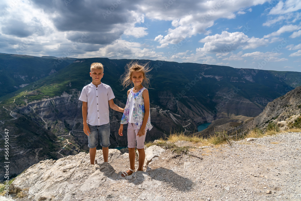 Teen boy with his sister stands on cliff of picturesque Sulak river canyon in Dagestan Teen boy with his sister stands on cliff of picturesque Sulak river canyon in Dagestan