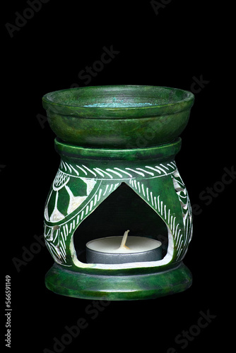 green ceramic aroma lamp with candles on a black background. photo