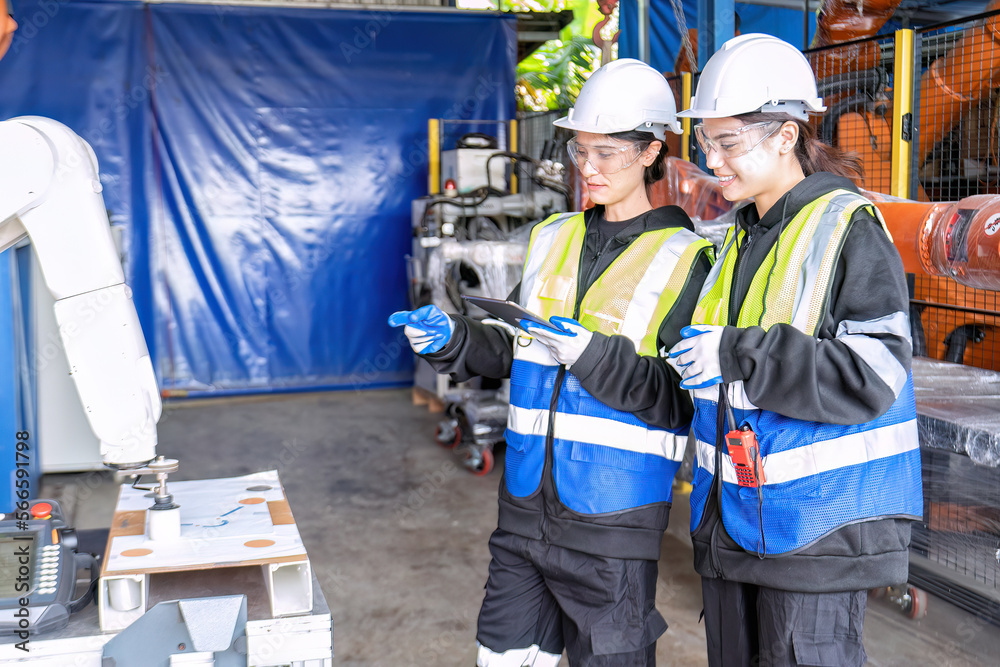 Women engineer team together at work in modern advanced robot welding machine sell service factory Women engineer team together at work in modern advanced robot welding machine sell service factory