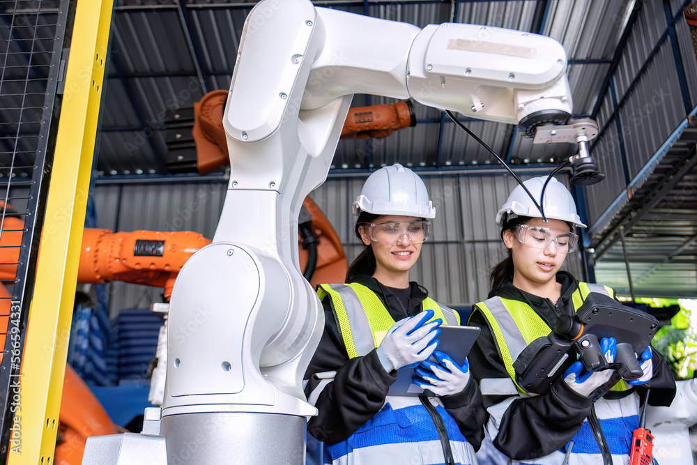 Women engineer team together at work in modern advanced robot welding machine sell service factory Women engineer team together at work in modern advanced robot welding machine sell service factory