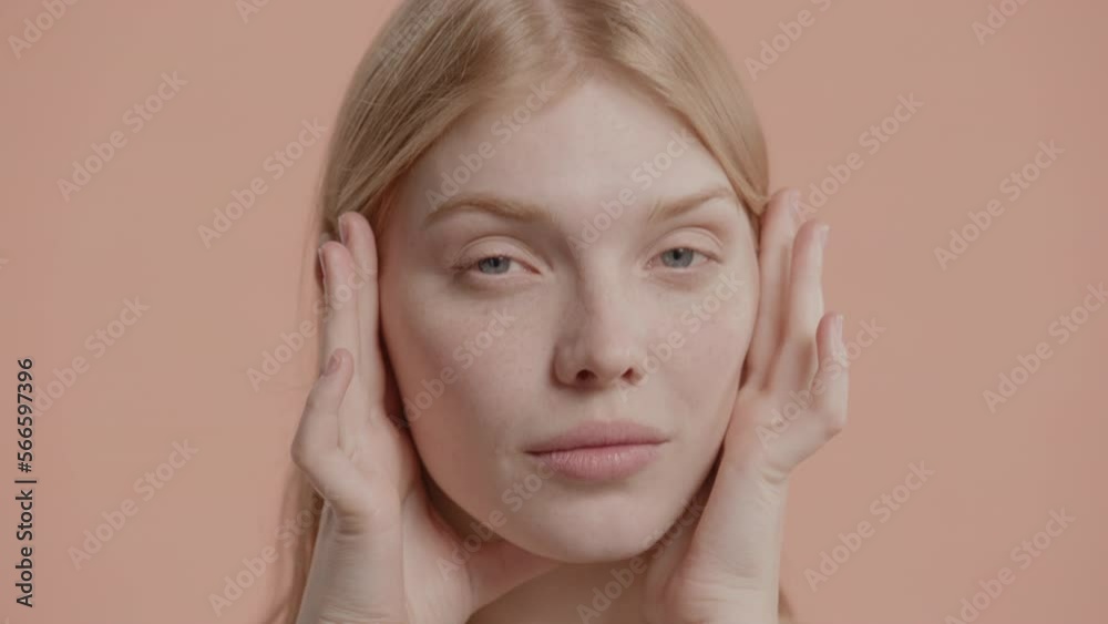 CU Portrait of natural beauty 20s Caucasian female doing her skincare routine against pastel colored background. No make-up, clean skin CU Portrait of natural beauty 20s Caucasian female doing her skincare routine against pastel colored background. No make-up, clean skin