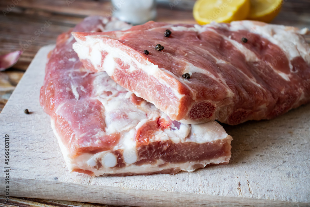 Raw pork ribs with rosemary and black pepper. on a wooden background