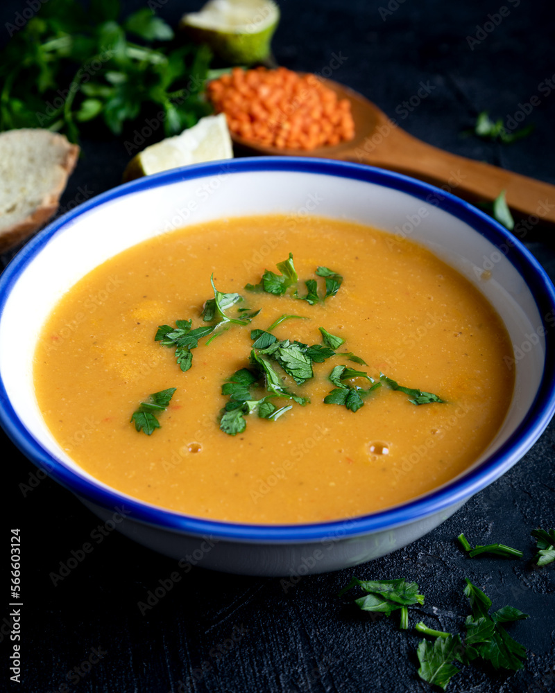 Red lentil soup puree in a bowl  on dark background. Traditional middle eastern cuisine. Vegan food .