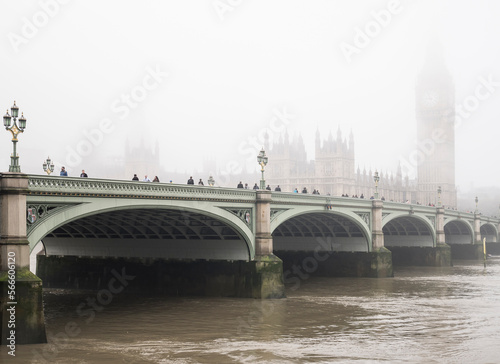 Commuters struggle into work over Westminster Bridge, London, on a cold, foggy, misty morning. River Thames can be seen  in foreground. photo