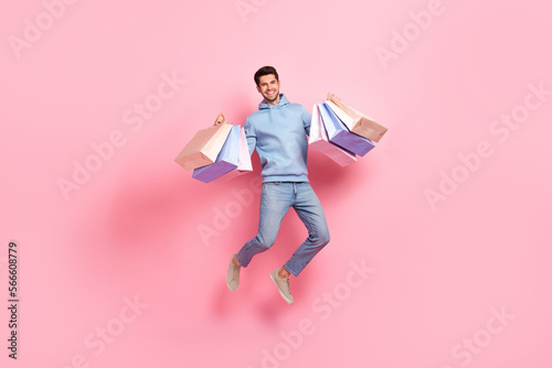 Full length photo of positive man rejoice nice shopping low prices trendy clothes new collection isolated on pink color background