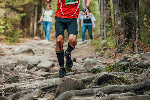 athlete runner with blood on his knees run forest trail