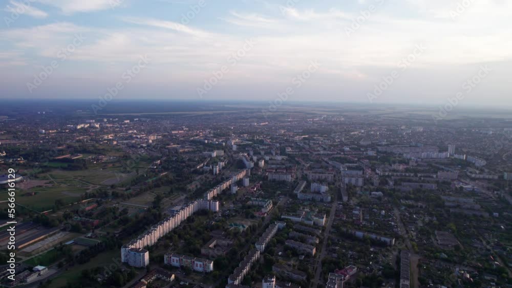 Aerial view of city panorama at sunset with residential neighborhoods and factory areas against a blurred skyline Aerial view of city panorama at sunset with residential neighborhoods and factory areas against a blurred skyline