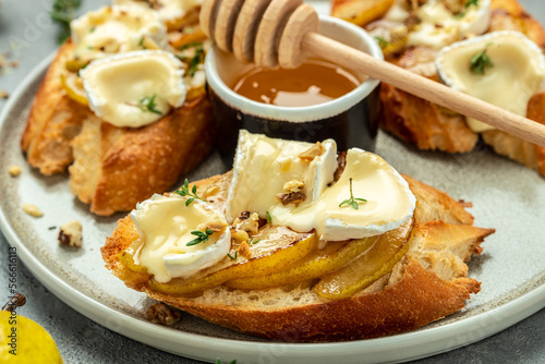Pear and brie crostini with honey, walnut and thyme, New Years Eve or Christmas party appetizer. banner, menu, recipe place for text, top view