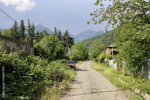 dusty street in a village with trees and mountains, Mestia, Svanetia, Georgia photo