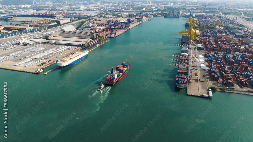container ship and commercial port load and unloading cargo from container ship by crane to trailers transported aerial view
