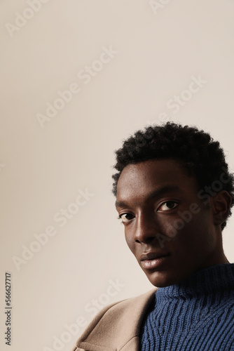 Young African American man looking at the camera. Vertical mock-up. © face_reader_img