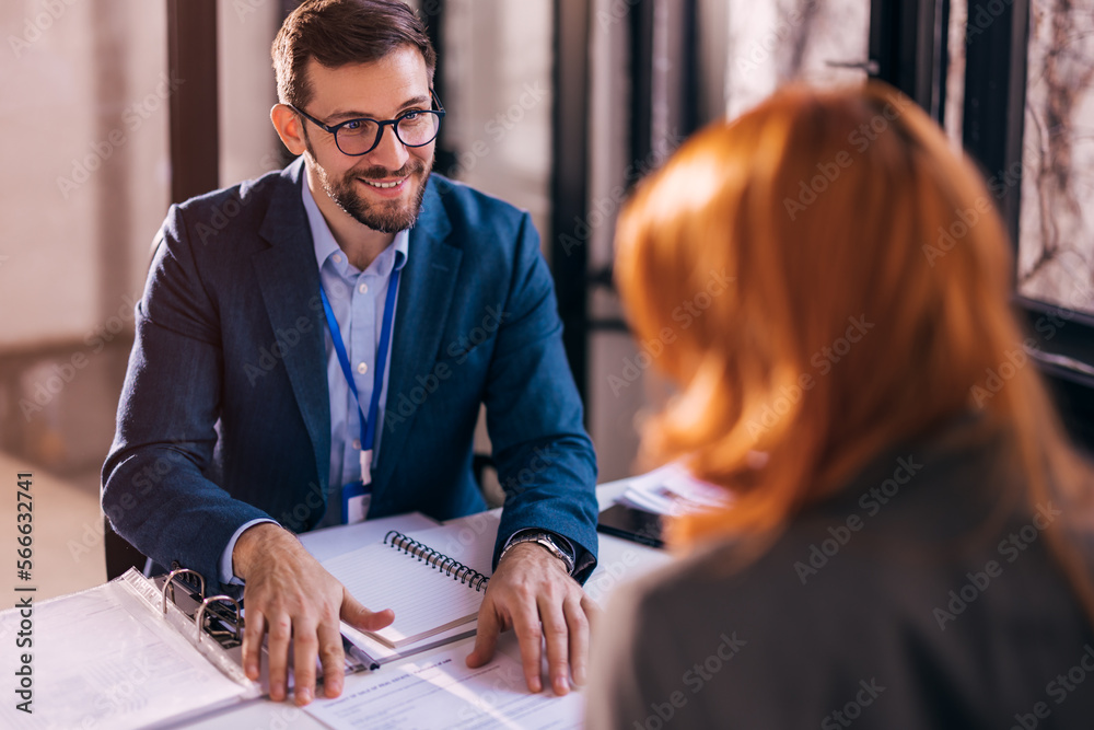 © kerkezz - The real estate agent closes the deal with the client and they sign the contract.