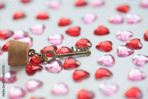 Glass bottle, key with the word love and heart shape gems on white background. Valentine's Day concept.