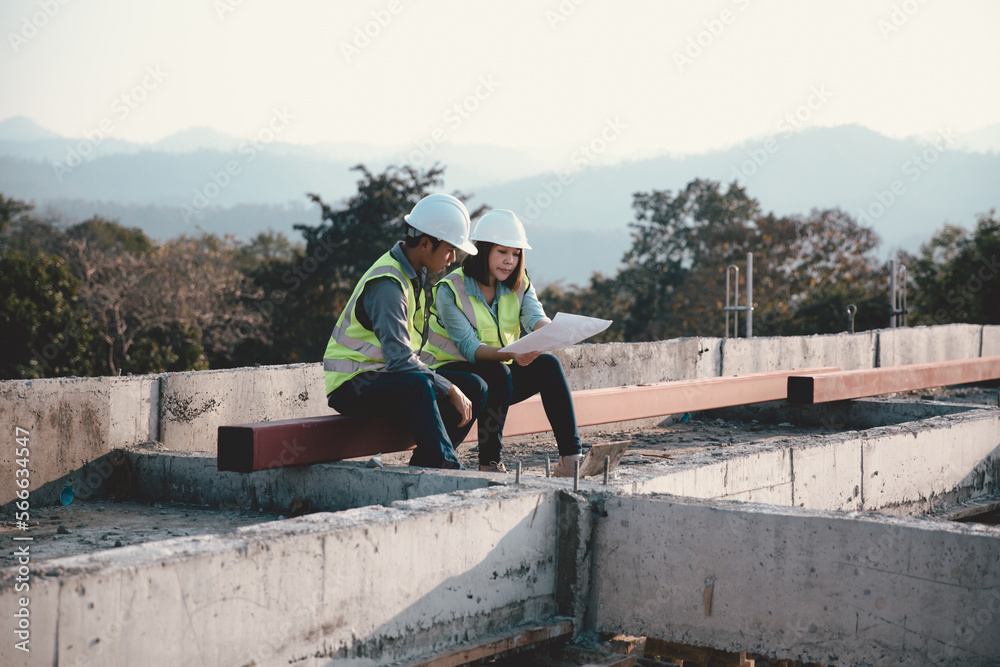 Two specialists inspect commercial, Industrial building construction site. Real estate project with civil engineer, designing commercial buildings on paper. Skyscraper concrete formwork frames.