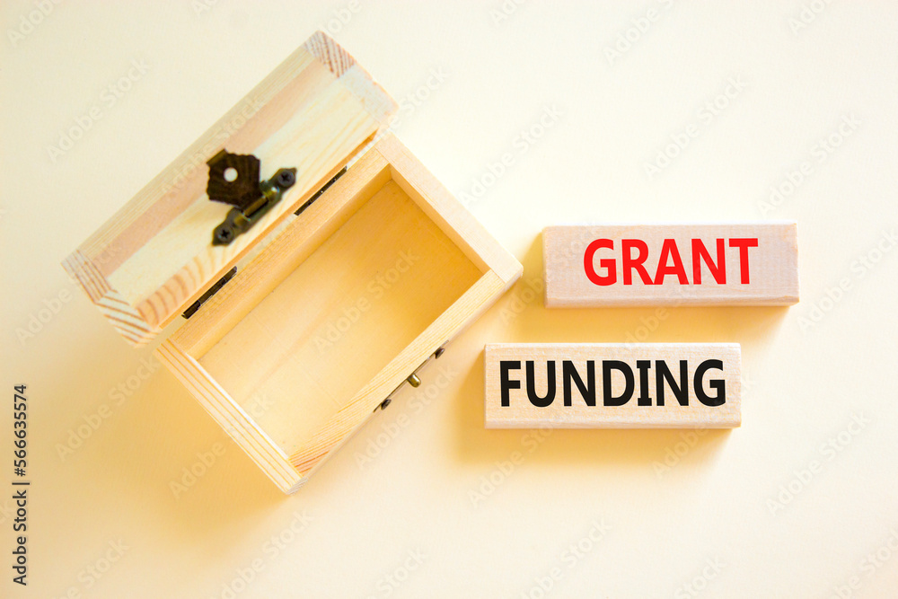 Grant funding symbol. Concept words Grant funding on wooden blocks. Beautiful white table white background. Wooden empthy chest. Business and grant funding concept. Copy space. Grant funding symbol. Concept words Grant funding on wooden blocks. Beautiful white table white background. Wooden empthy chest. Business and grant funding concept. Copy space.