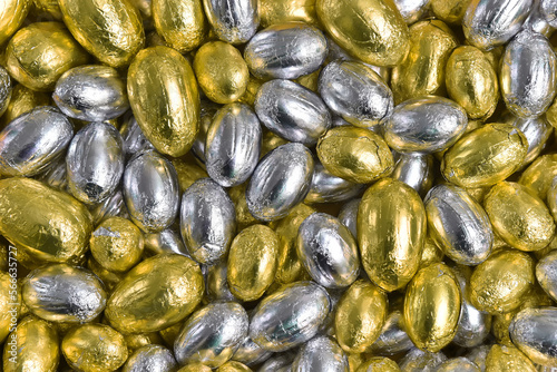 Canvas Print Large & small yellow, gold and silver foil wrapped chocolate easter eggs making a great background