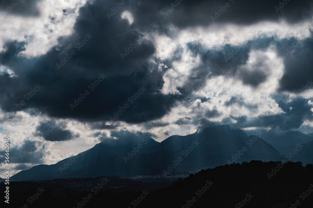 dramatic sky with huge dark clouds over rugged mountain silhouettes in Spain