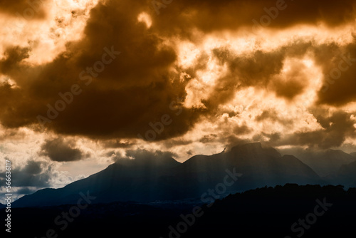 dramatic sky with huge dark clouds over rugged mountain silhouettes in Spain © mirafoto