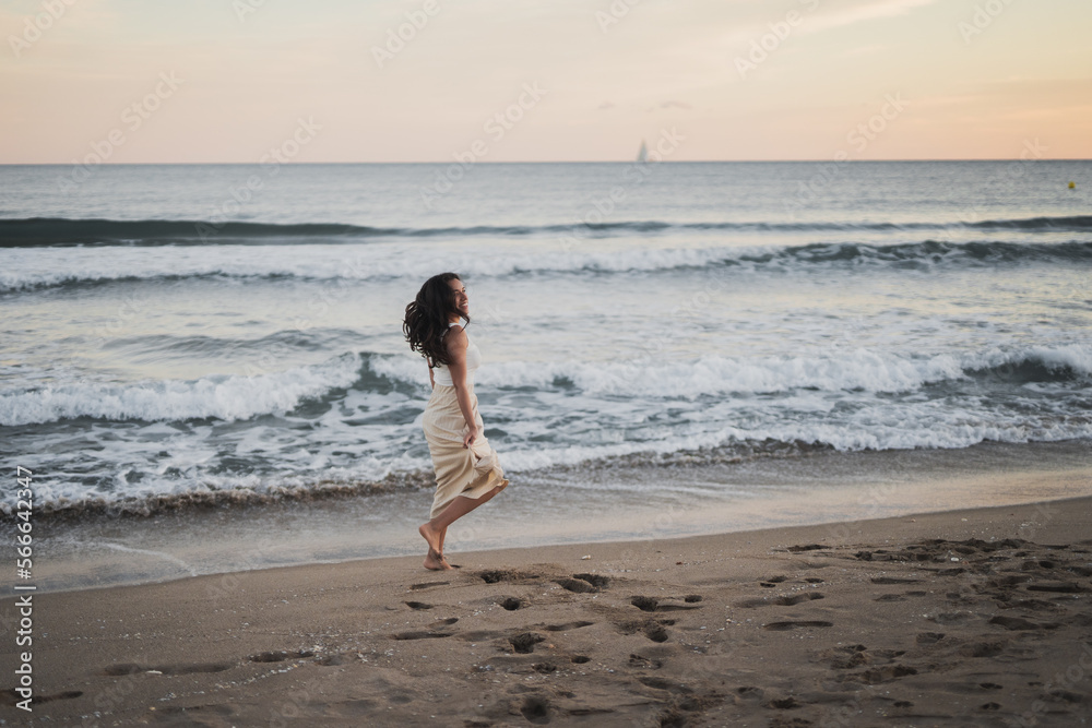 Cheerful young ethnic woman walking on sandy seashore during summer vacation Cheerful young ethnic woman walking on sandy seashore during summer vacation