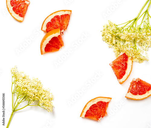 Pieces of grapefruit and elderflower on a white background