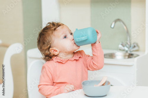 Little girl drinking water from a plastic cup