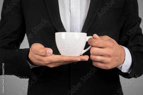 Unrecognizable Businessman Wearing Suit Holding Cup Of Coffee In Hands