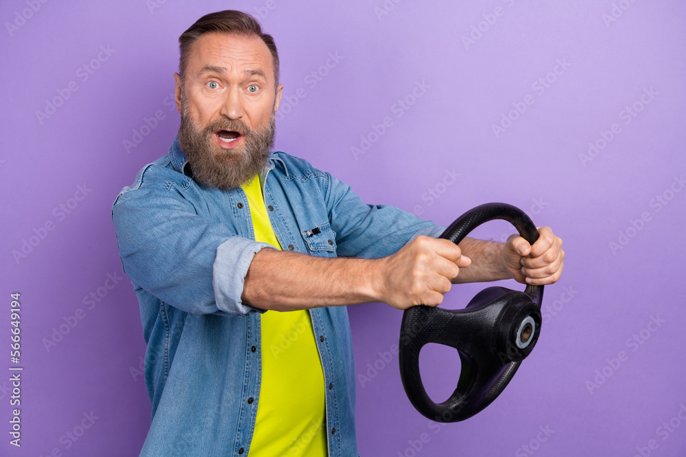 Profile photo of impressed aged man arms hold wheel open mouth isolated on violet color background Profile photo of impressed aged man arms hold wheel open mouth isolated on violet color background