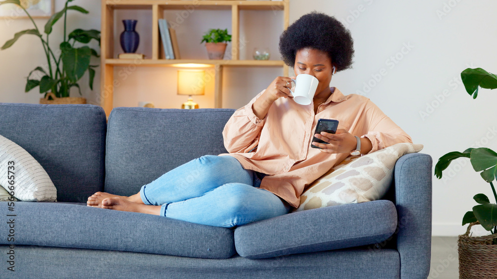 Φωτογραφία Laughing woman listening to music and sending a message with funny memes on her phone and drinking coffee while on the sofa