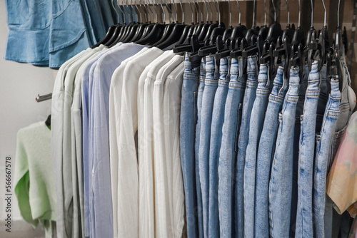 women's jeans and sweaters in pastel colors hang on a hanger in the store