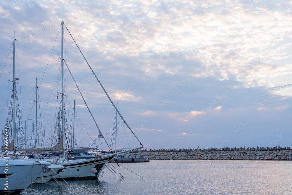 sailing boats in the harbor against cloudy sky, sunset, space for design, panorama, background