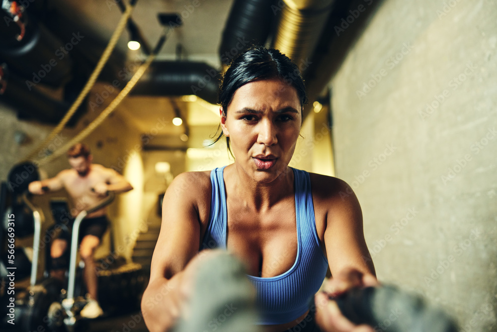 Woman exercising with battle ropes Woman exercising with battle ropes