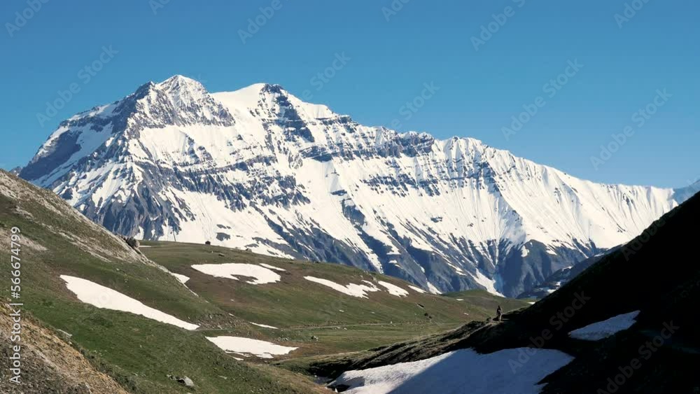 Sommet enneigé avec plateau herbeux et randonneuse en avant plan - Grande Casse, Parc National de la Vanoise