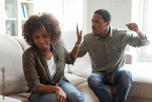 Photo Angry black man raising hand against his scared wife