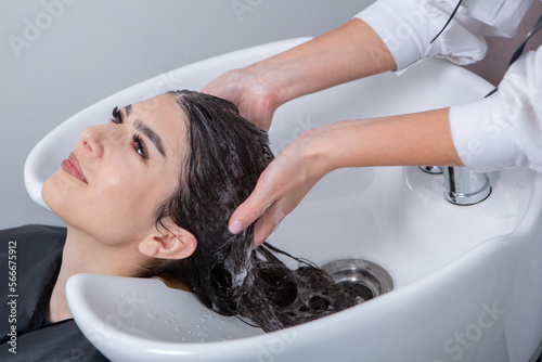 professional hairdresser washing hair of young woman in beauty salon. close up of woman's hair in beauty salon, hairstyle concept