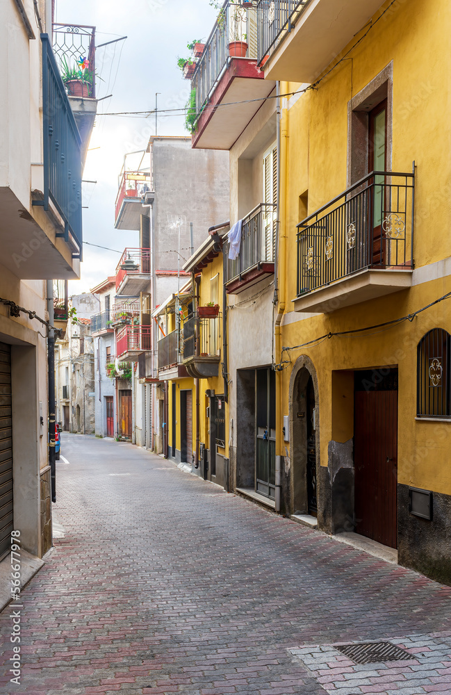 Fototapeta premium beautiful narrow medeterranean street with vintage buildings , beautiful windows and picturesque balcony with attributes of traditional italian country life