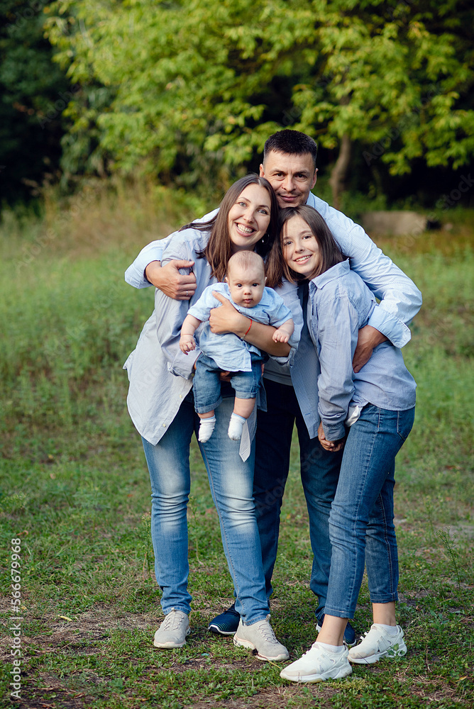 Fototapeta premium friendly family kid dream concept. lifestyle family walking in the park on the grass at sunset.