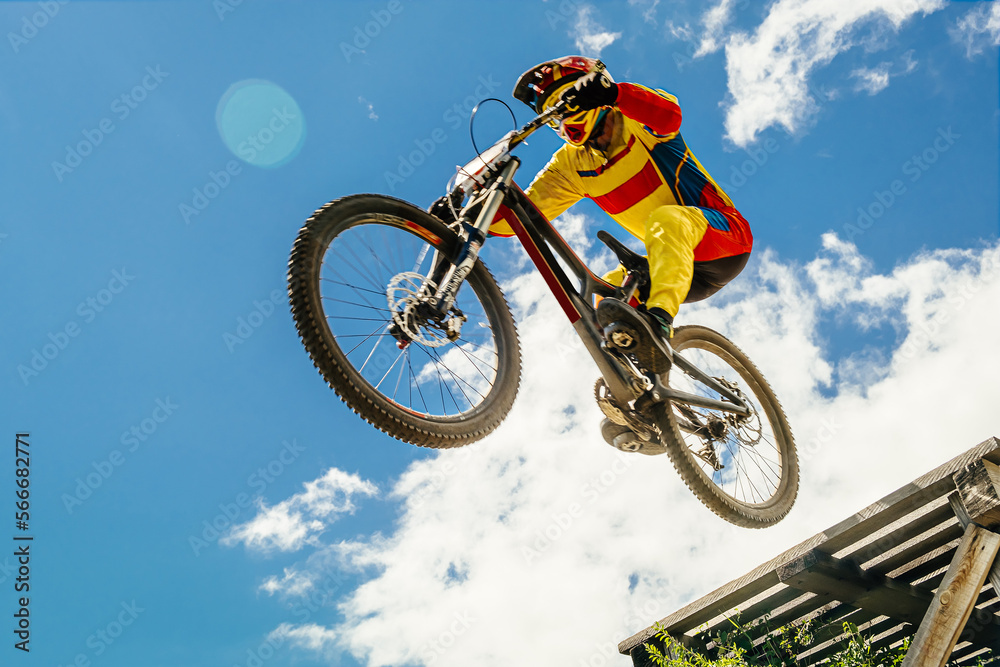 cyclist drops downhill in bokeh background blue sky cyclist drops downhill in bokeh background blue sky