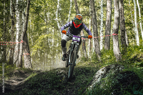 athlete rider riding forest trail in downhill race