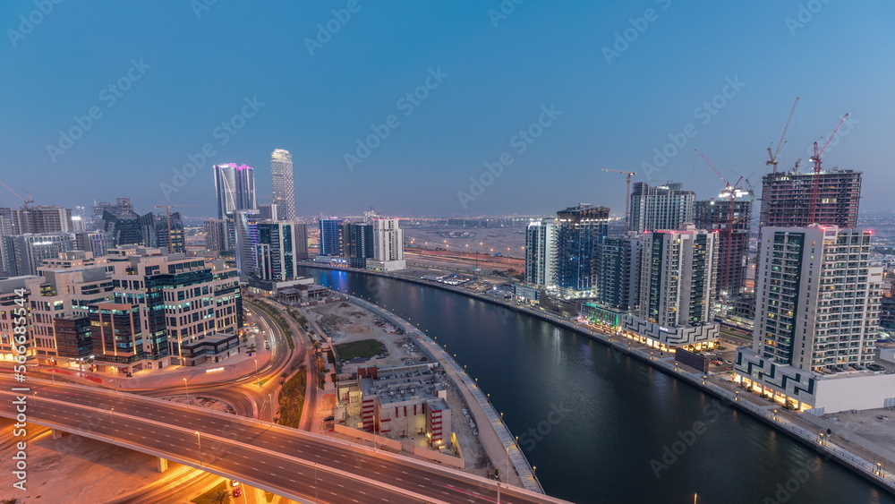Skyscrapers at the Business Bay aerial day to night in Dubai, United Arab Emirates