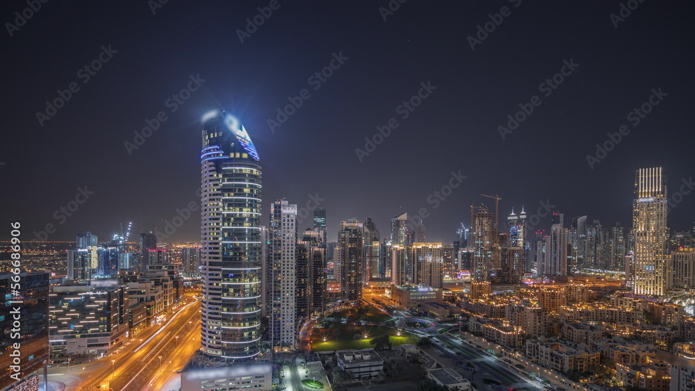 Panorama showing Dubai's business bay towers aerial night . Rooftop view of some skyscrapers