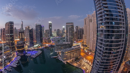 Aerial view to Dubai marina skyscrapers around canal with floating boats night to day © neiezhmakov