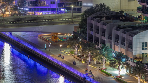 Dubai Marina waterfront and city promenade aerial night .
