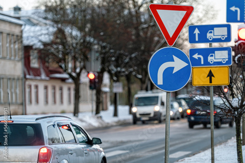 Cars moving on the road in city in winter. View to the traffic with signs, trafficlights and cars