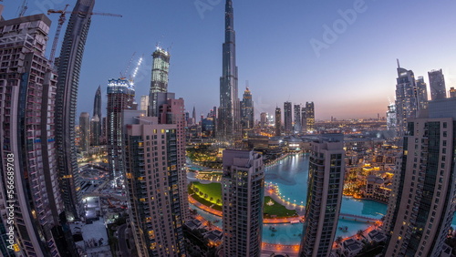 Panorama of Dubai Downtown cityscape with tallest skyscrapers around aerial night to day .