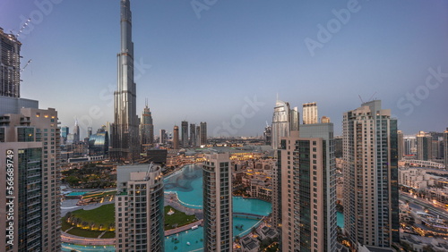 Dubai Downtown cityscape with tallest skyscrapers around aerial day to night .