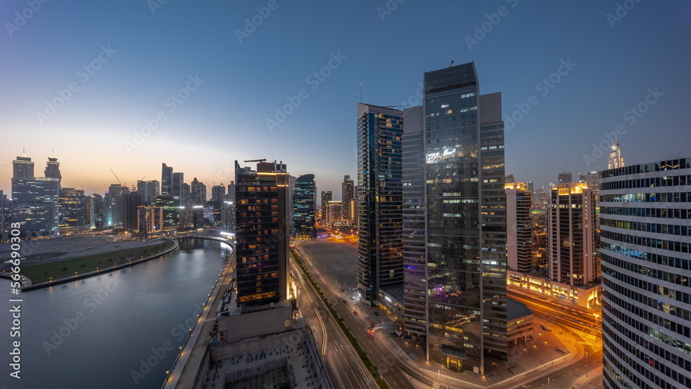 Cityscape of skyscrapers in Dubai Business Bay with water canal aerial day to night